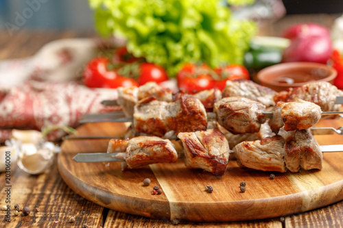 Juicy kebabs from pork on skewers laid out on a decorative board.