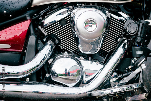 Closeup of motorbike with lots of chrome details. Modern powerful perfomance road motorcycle shiny reflexive surface engine with exhaust pipes. Vehicle industry. Two-wheeled vehicle technologies.