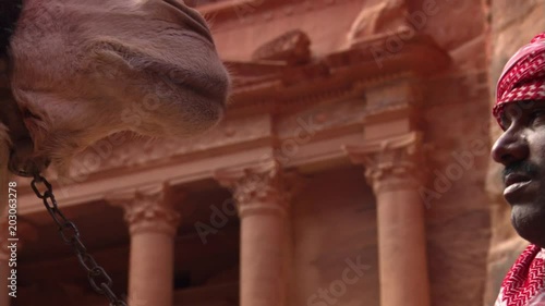 Close-up faces of Jordanian man and his camel at Petra photo