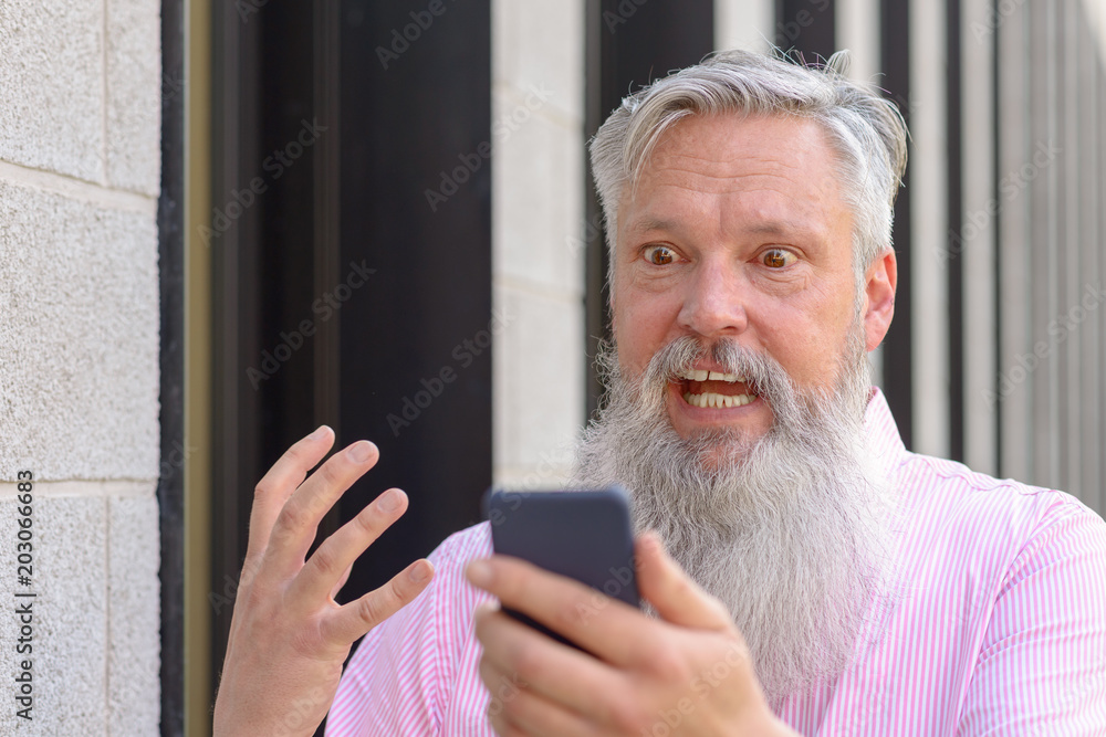 Emotional bearded man looking at his mobile Emotional bearded man looking at his mobile