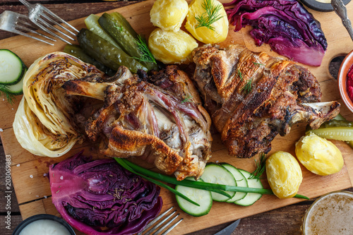 Photography Baked pork knukle or eisbein on wooden board with beer