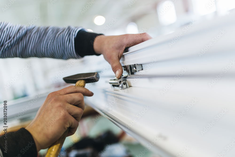 Manual worker assembling PVC doors and windows. Manufacturing jobs