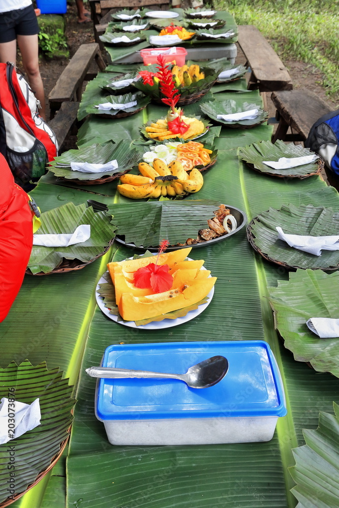 Filipino banquet long table with banana leaves tablecloth lunch