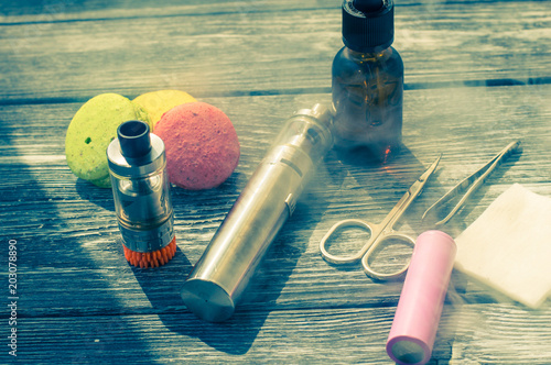 Still life with e-cig and jiuce on the wooden background photo