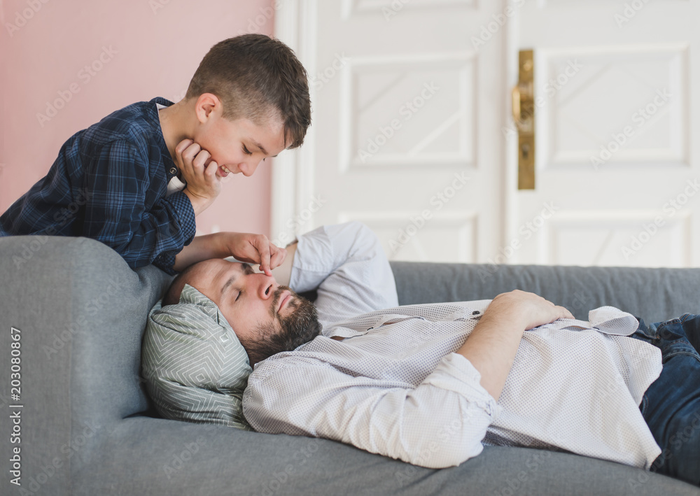 Smiling boy wakes up a father.