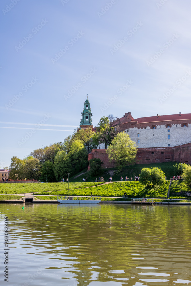 Naklejka premium Le château du Wawel à Cracovie depuis un bateau sur Le Vistule
