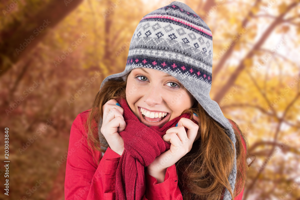 Cold redhead wearing coat and hat against tranquil autumn scene in forest Cold redhead wearing coat and hat against tranquil autumn scene in forest