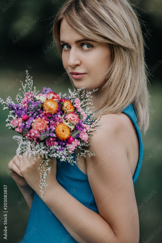 Portrait of beautiful blonde with bouquet of flowers Portrait of beautiful blonde with bouquet of flowers