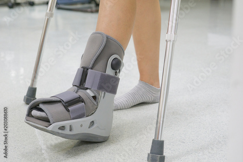 Fototapeta Orthopaedic Boot and crutch to a Patient