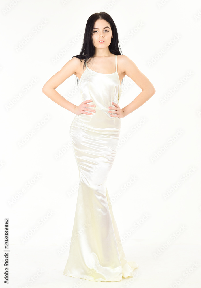 Elegant dress concept. Girl on pensive face in graceful dress. Fashion model wears expensive fashionable evening dress or wedding dress. Woman in elegant white dress with long hair, white background.