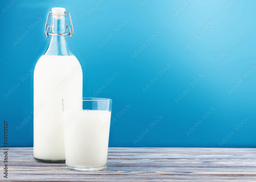 a glass of milk, a bottle of milk on a wooden table a glass of milk, a bottle of milk on a wooden table