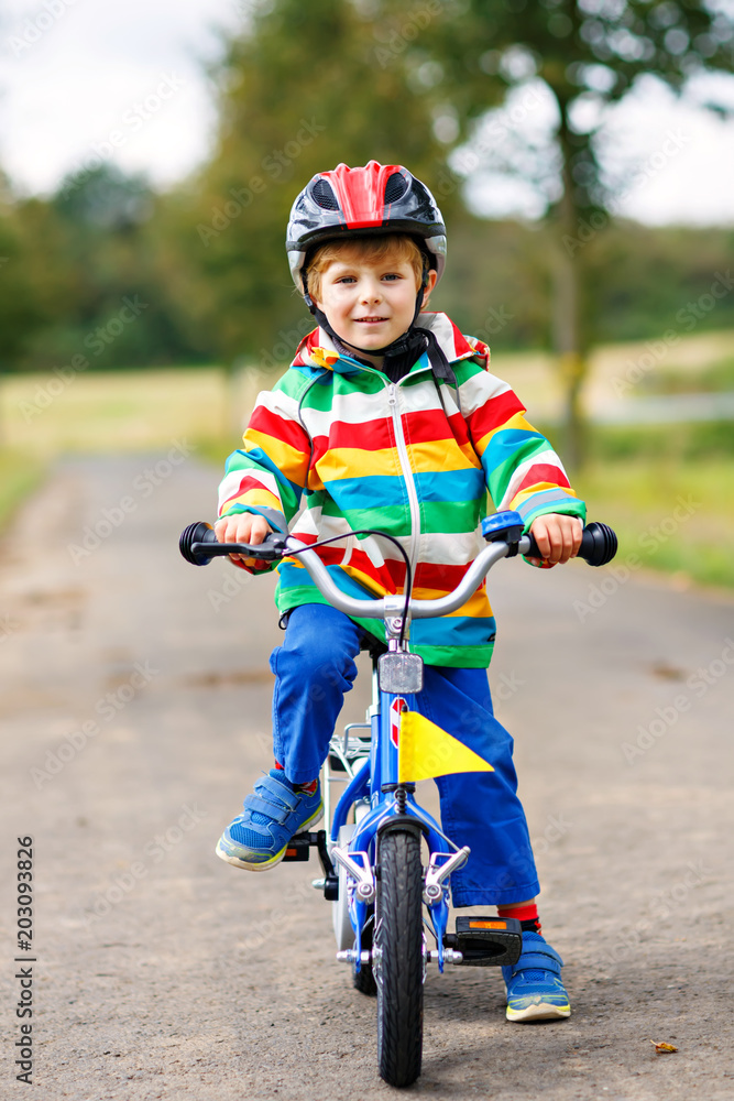 Little cute kid boy on bicycle on summer or autmn day. Healthy happy child having fun with cycling on bike.
