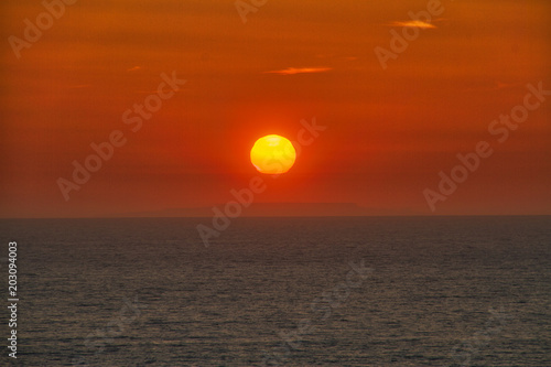 Fototapeta Naklejka Na Ścianę i Meble -  The sun setting over the Pacific Ocean off the coast of California.