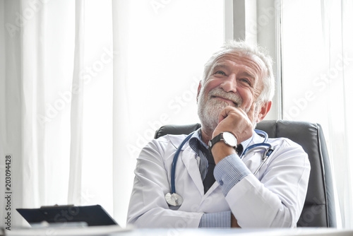 Happy Senior male Doctor is thinking.