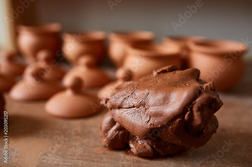 Fotografie Large piece of red clay closeup on worktop at the potter workshop, close-up, sha