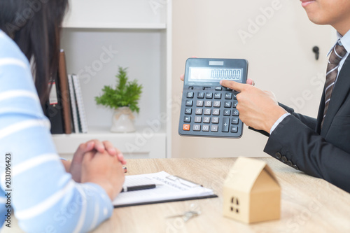 Businessman showing the home price on calculator - meeting a real estate advisor