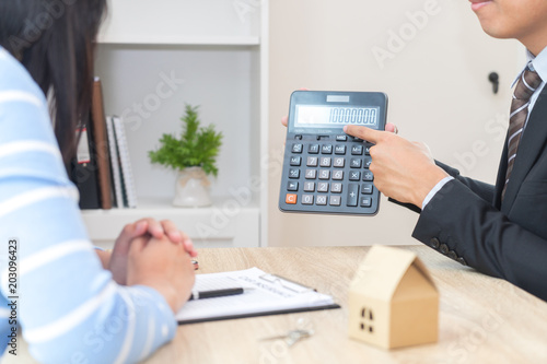 Fotografie Businessman showing the home price on calculator - meeting a real estate advisor
