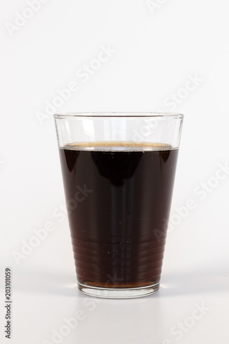 Ein Glas mit brauner Liomonade isoliert auf weißem Hintergrund