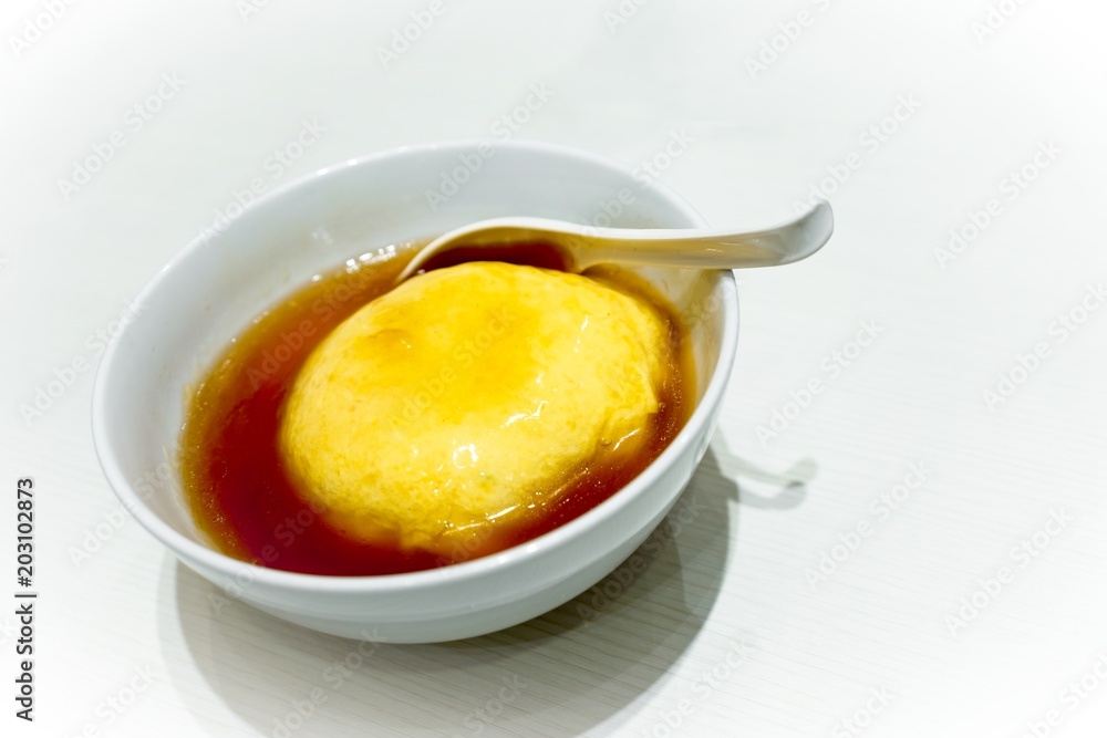 Tenshinhan or Tenshindon/crab omelet on rice in white bowl on white background with copy space. Tenshindon is a Japanese-Chinese specialty, consisting of a crab meat omelette on rice. Tenshinhan or Tenshindon/crab omelet on rice in white bowl on white background with copy space. Tenshindon is a Japanese-Chinese specialty, consisting of a crab meat omelette on rice.