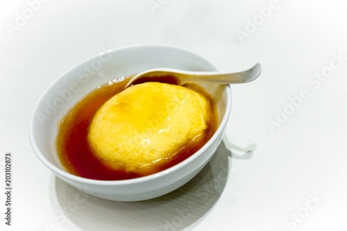Tenshinhan or Tenshindon/crab omelet on rice in white bowl on white background with copy space. Tenshindon is a Japanese-Chinese specialty, consisting of a crab meat omelette on rice.