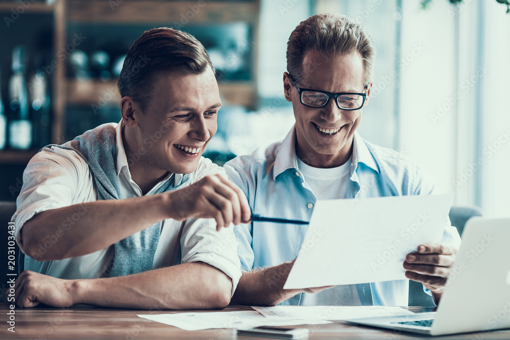 Two business partners are discussing business in cafe.
