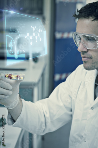 Science and medicine graphic against male scientist analyzing pills in the laboratory