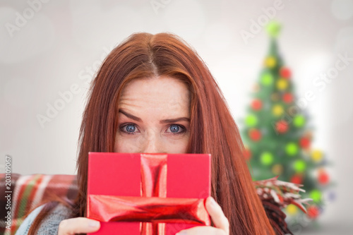 Woman holding gift against ...