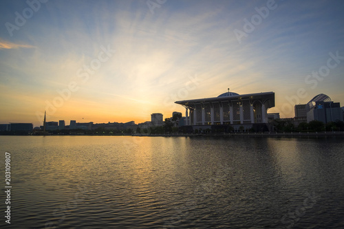 Scenery of Sunrise at Sultan Mizan Mosque,Putrajaya with clear blue sky and reflection. soft focus,blur due to long exposure. visible noise due to high ISO.