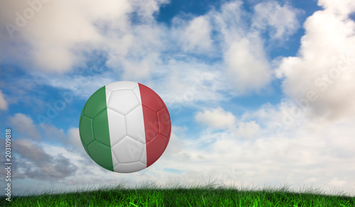 Football in italy colours against green grass under blue sky