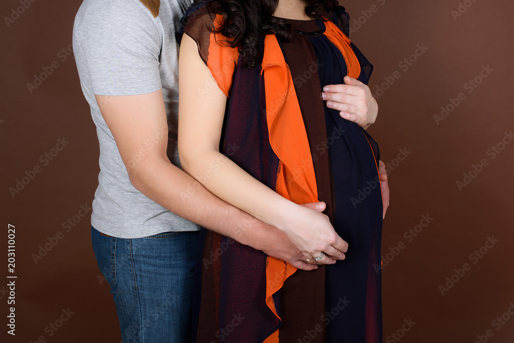 Fototapeta premium beautiful young couple expecting baby. Pregnant couple holding the belly