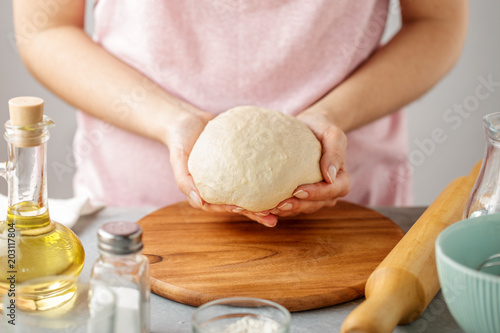 Female hands hold the dough for making tortillas.