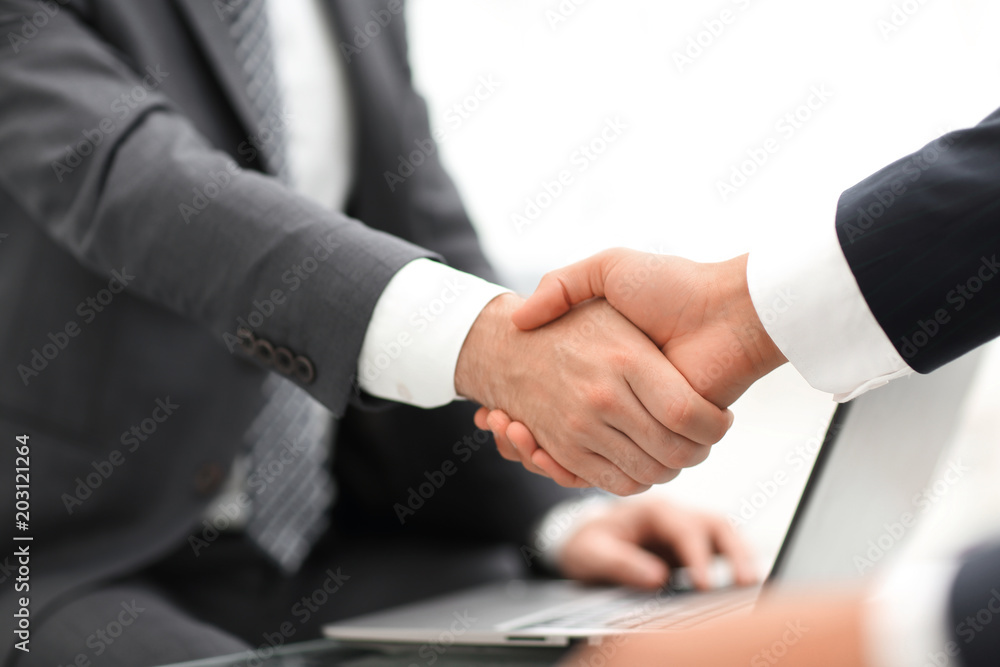 Closeup of business people shaking hands over a deal Closeup of business people shaking hands over a deal