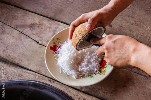 Billede på lærred Woman using hand scraping coconut put the container for make dessert