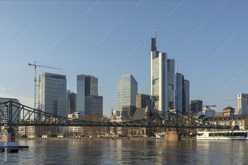 panoramic view of skyline of Frankfurt with old iron foot bridge
