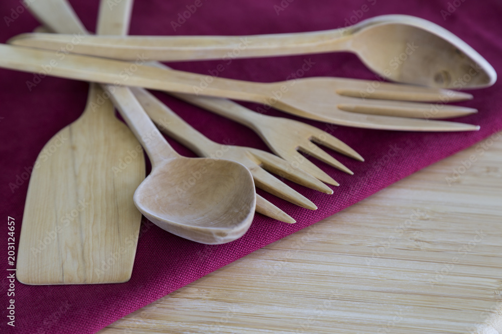 wooden handmade fork,spoon and spatula on the red service napkin for kitchenware concept.
