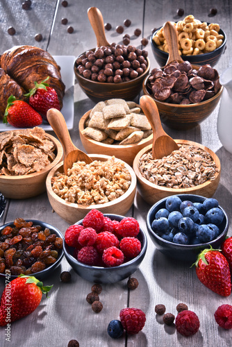 Different sorts of breakfast cereal products and fresh fruits photo