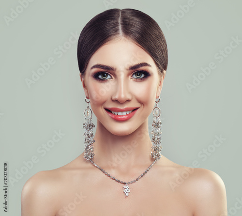Young Perfect Woman with Jewelry Necklace and Silver Earrings. Smiling Model Girl
