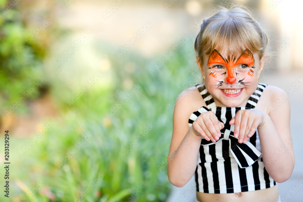 Naklejka premium Portrait of funny girl with face painting on blurred background