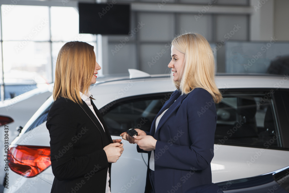 Young happy woman near the car with keys in hand - concept of buying car Young happy woman near the car with keys in hand - concept of buying car