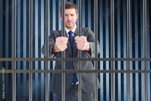 Businessman holding his hands out against dark grey room