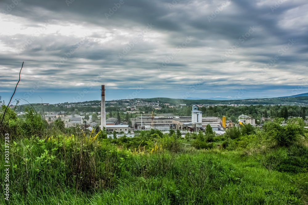 soft focus pollution concept with green valley on foreground and industrial factory on background soft focus pollution concept with green valley on foreground and industrial factory on background