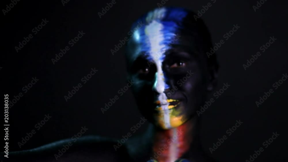 Body art portrait of a dark-skinned glowing girl with color make-up Body art portrait of a dark-skinned glowing girl with color make-up