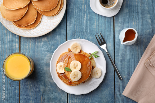 Flat lay composition with tasty pancakes and glass of juice on wooden background