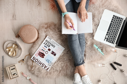 Female beauty blogger with notebook and laptop indoors, top view photo