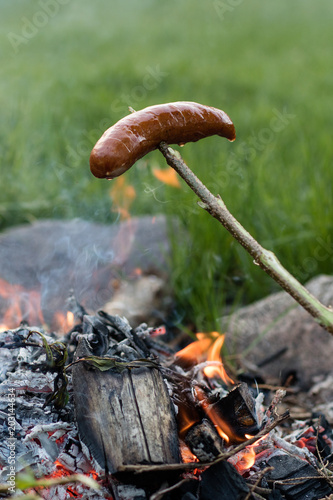 Tasty sausage prepared on the campfire. A holiday meal prepared in the open air.