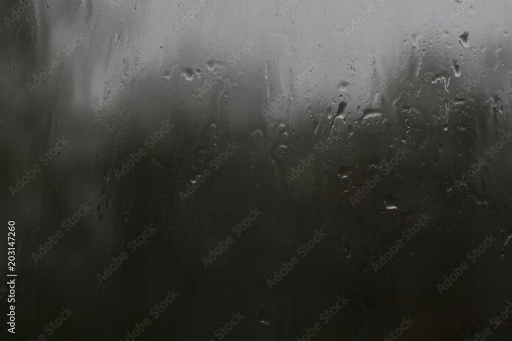rain drops on glass on a dark green background