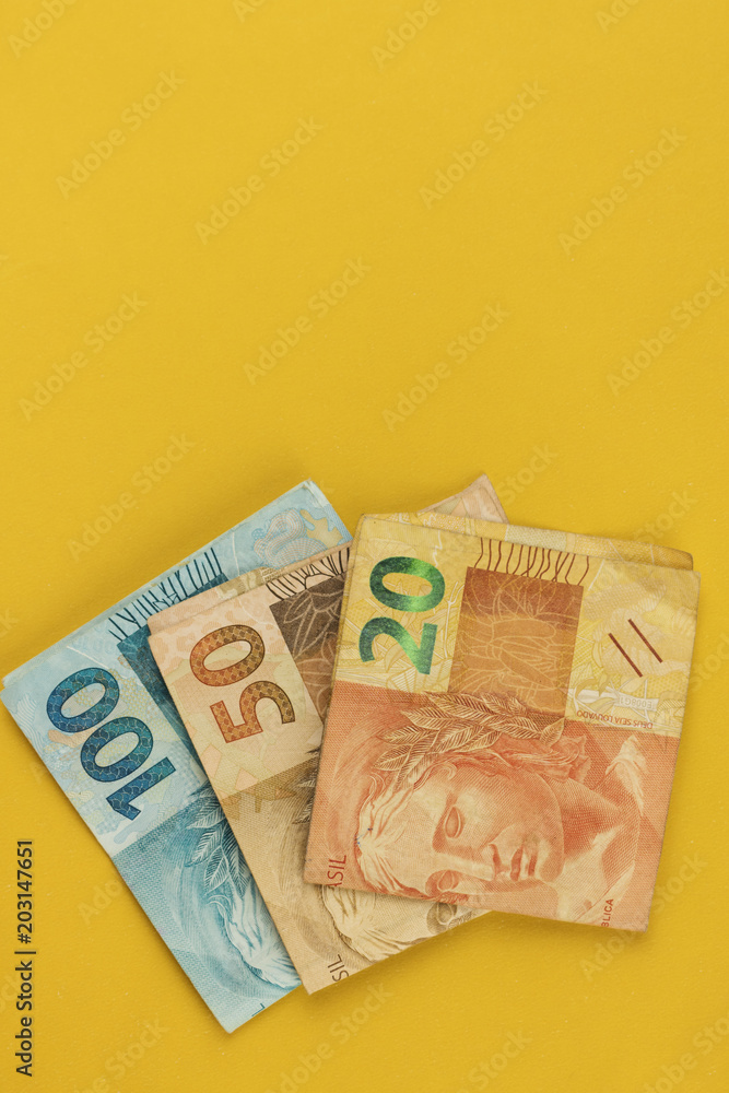 Obraz premium Varied values of Brazilian money isolared on yellow background