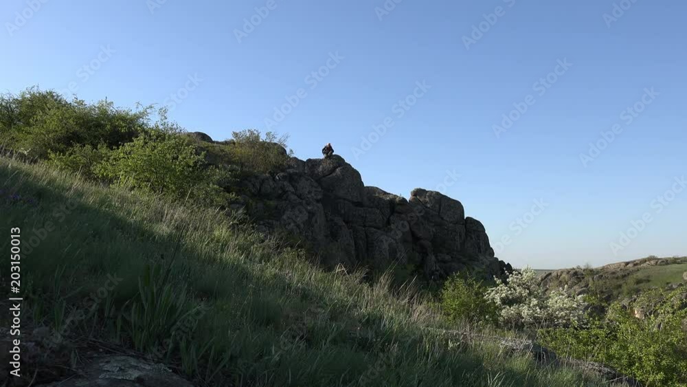 Mature man happily talks on the phone on the mountainside, a tourist backpack, Canyon, high elephant cliffs, National Park Mature man happily talks on the phone on the mountainside, a tourist backpack, Canyon, high elephant cliffs, National Park