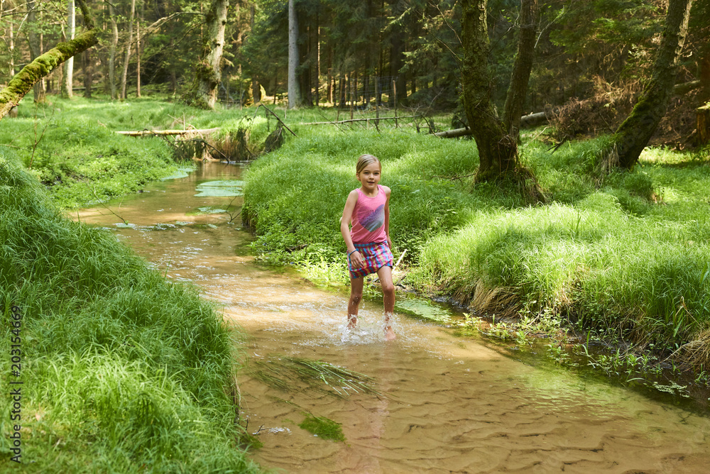 Child cute blond girl playing in the creek. Summer children fun.
Child cute blond girl playing in the creek. Summer children fun.