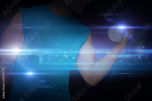 Close-up mid section of fit man exercising with dumbbell against black background with spark